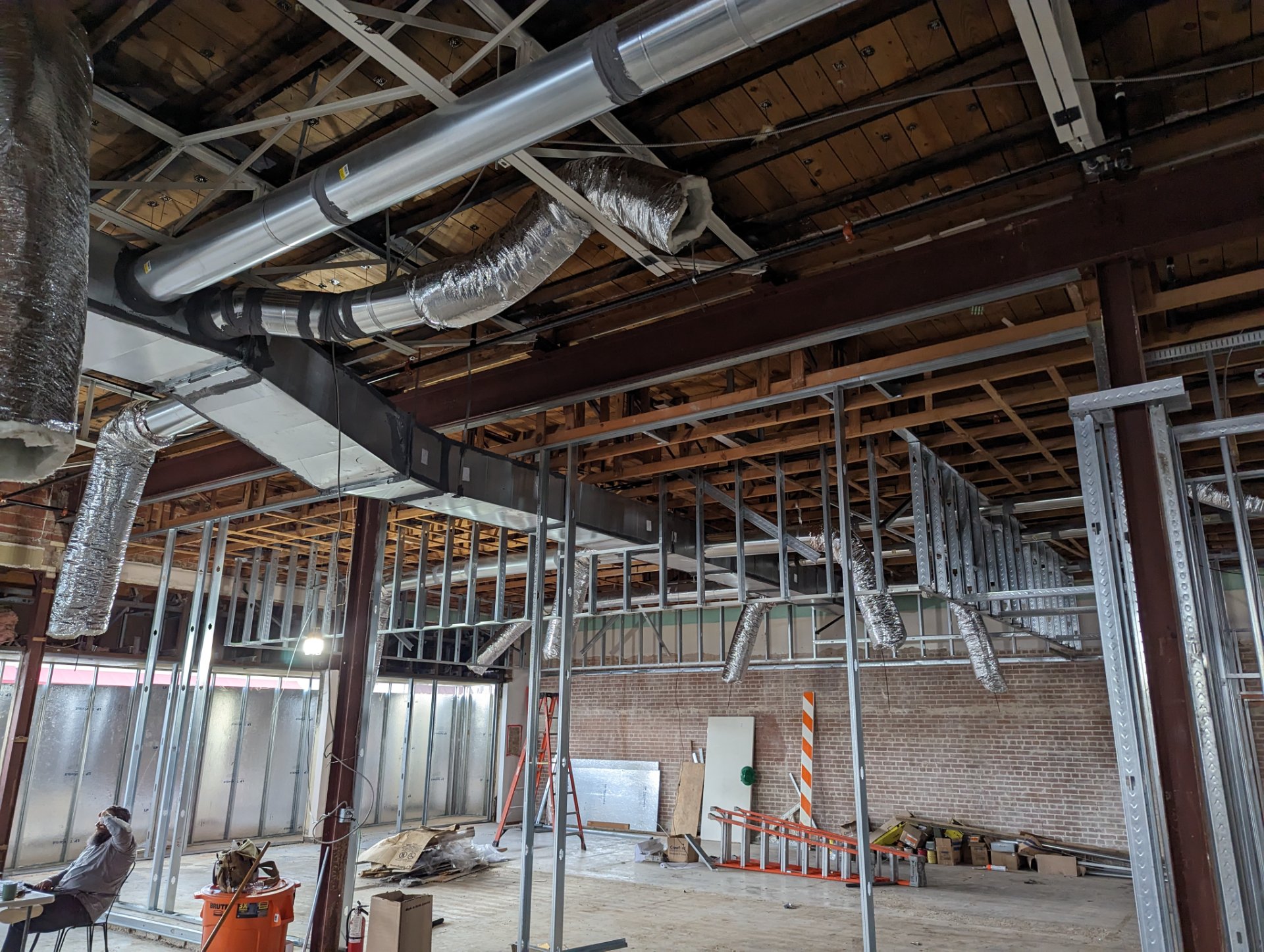 HVAC ductwork installation with rigid and flexible ducts in a commercial building under construction.