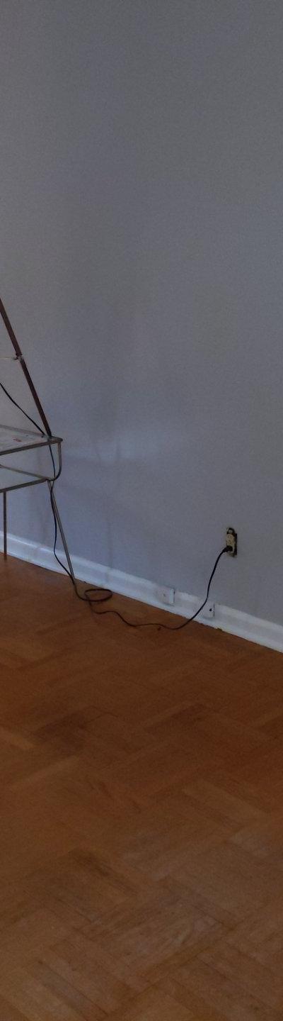 Two white Mitsubishi floor-mounted mini-split indoor units in a room with light grey walls and hardwood floor.